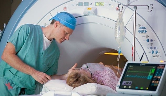 Technician comforting patient in MRI scanner